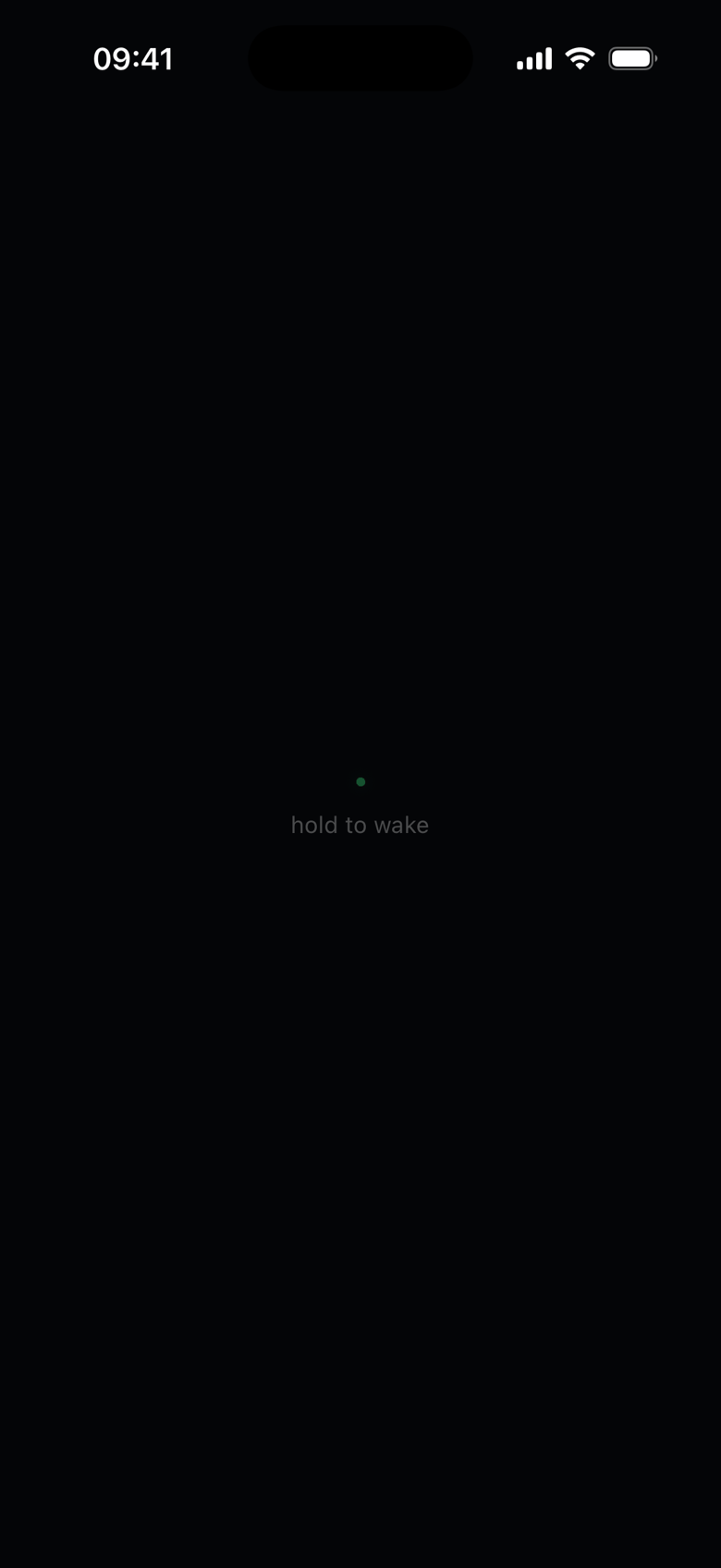 The powered-down face: a near-black screen with one dim green dot and the words 'hold to wake'.